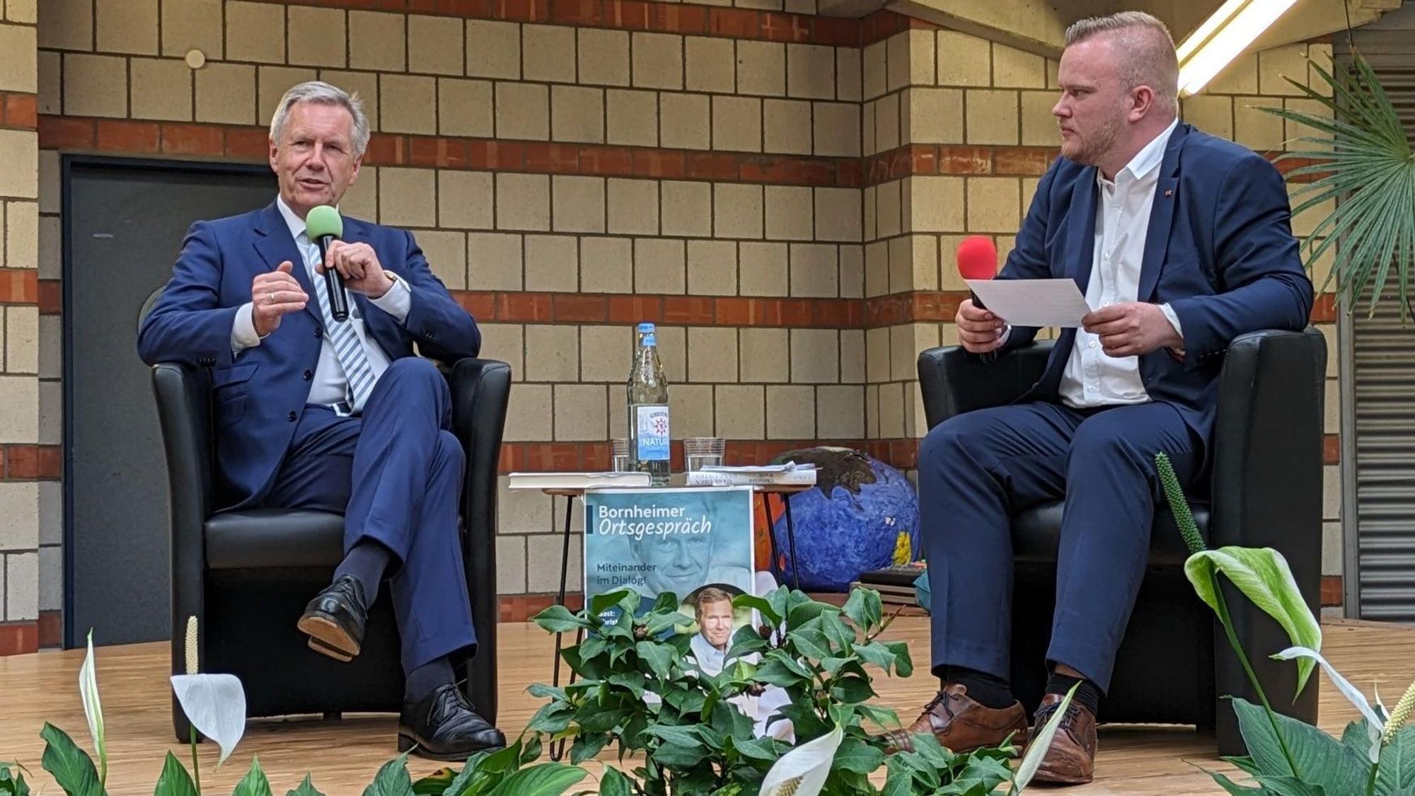 Altbundespräsident Christian Wulff spricht mit dem Bornheimer Ortsvorsteher Dominik Pinsdorf in der Oase der Europaschule.