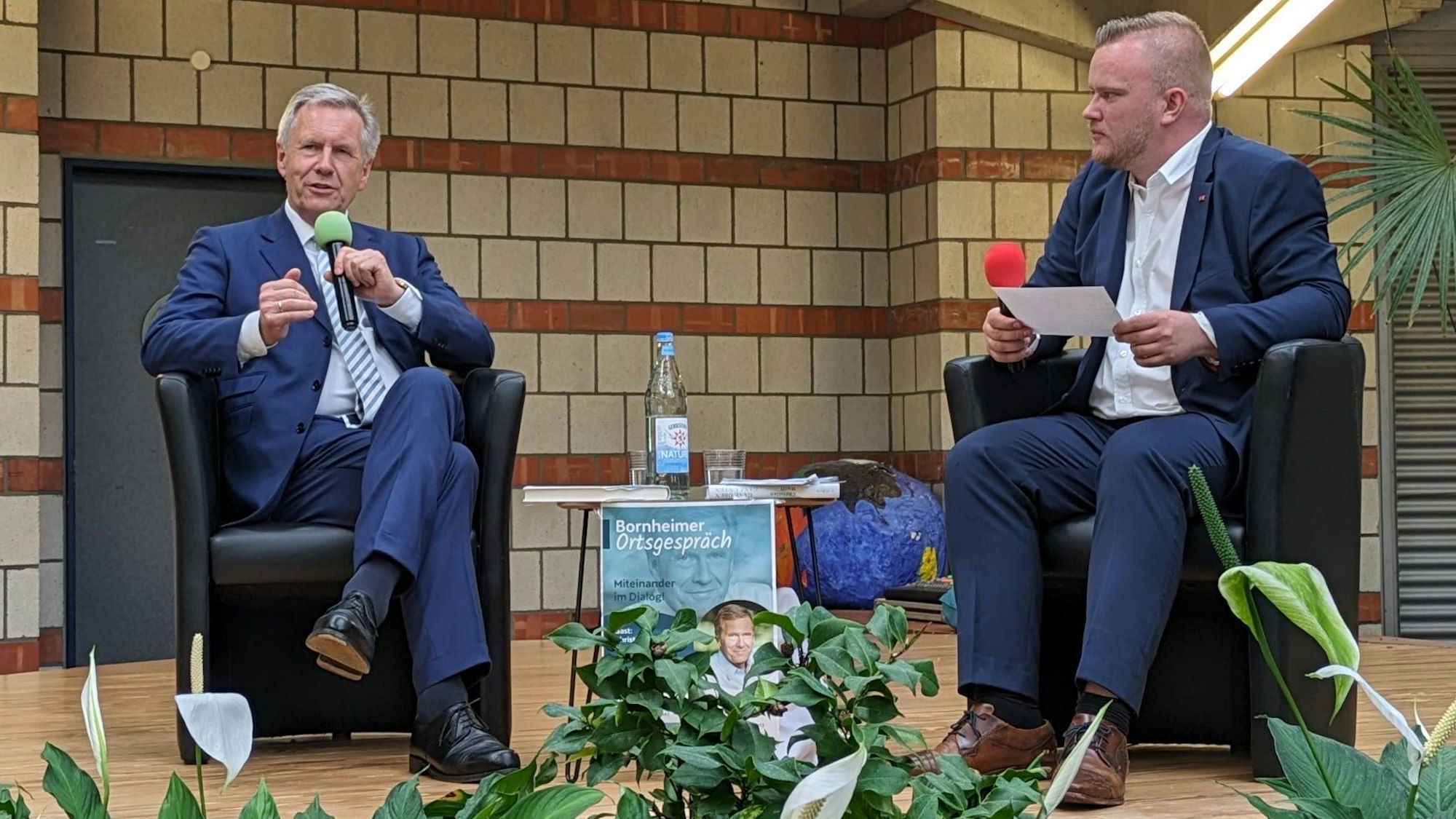 Altbundespräsident Christian Wulff spricht mit dem Bornheimer Ortsvorsteher Dominik Pinsdorf in der Oase der Europaschule.