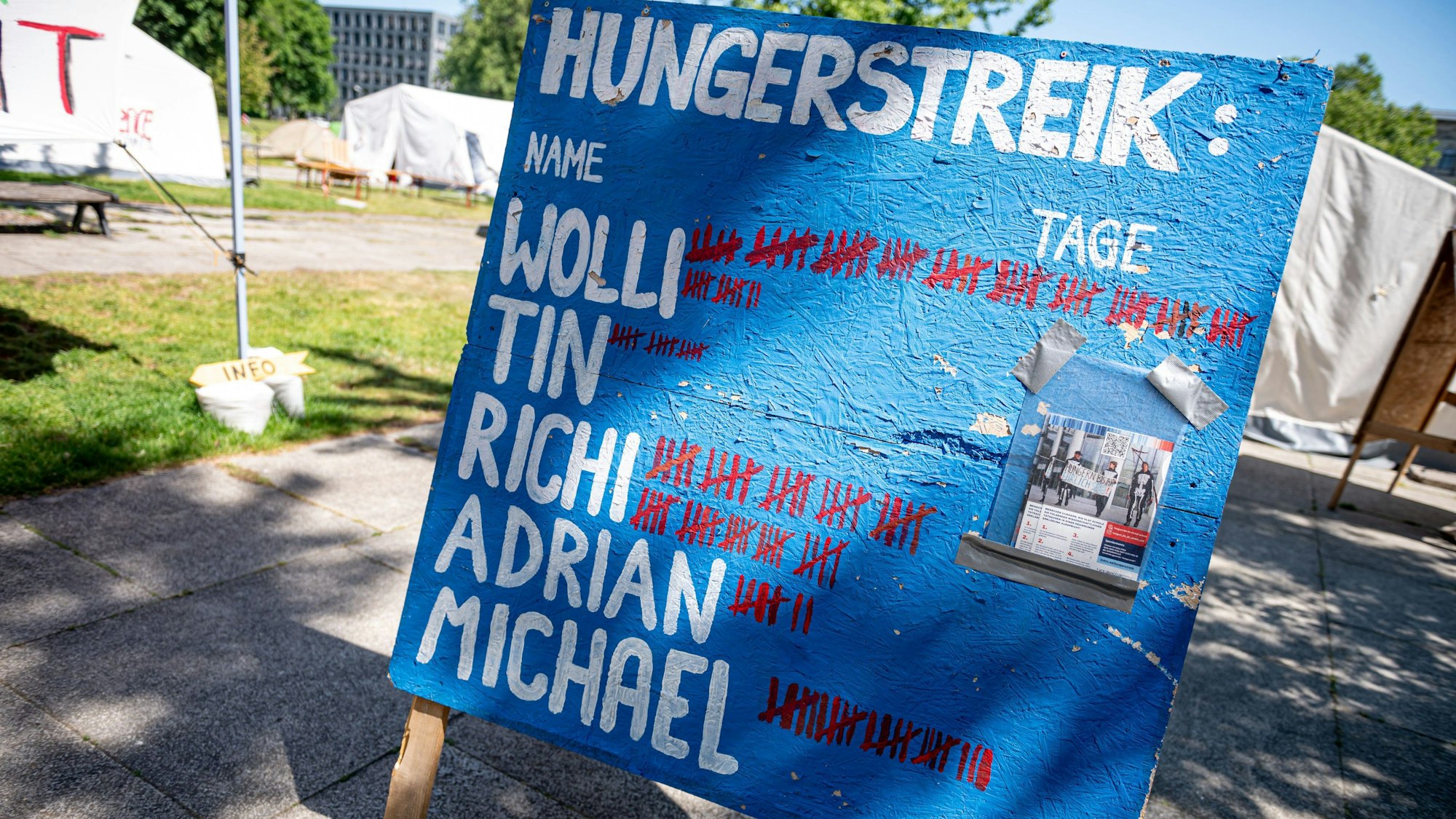 Auf einem Schild stehen die Namen der Hungerstreikenden und die Dauer des Hungerstreiks.
