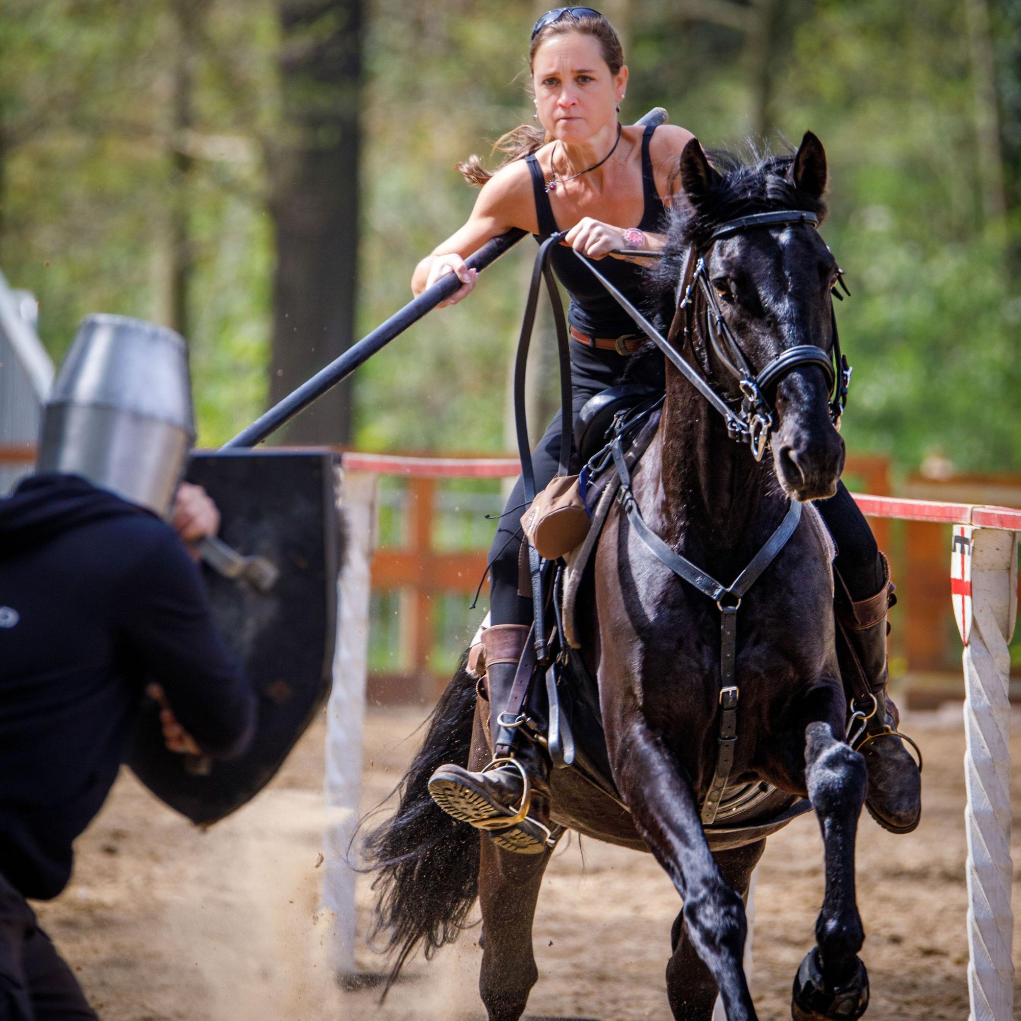 Patricia Gräfin Beissel reitet beim Training für die Ritterspiele mit einer Lanze auf einem schwarzen Pferd.