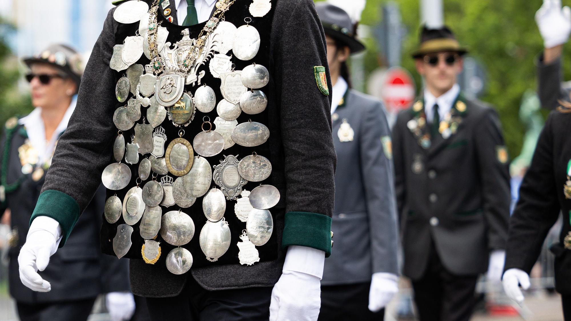 Ein Teilnehmer vom Schützenausmarsch trägt verschiedene Orden auf seiner Uniform und läuft durch die Innenstadt von Hannover.