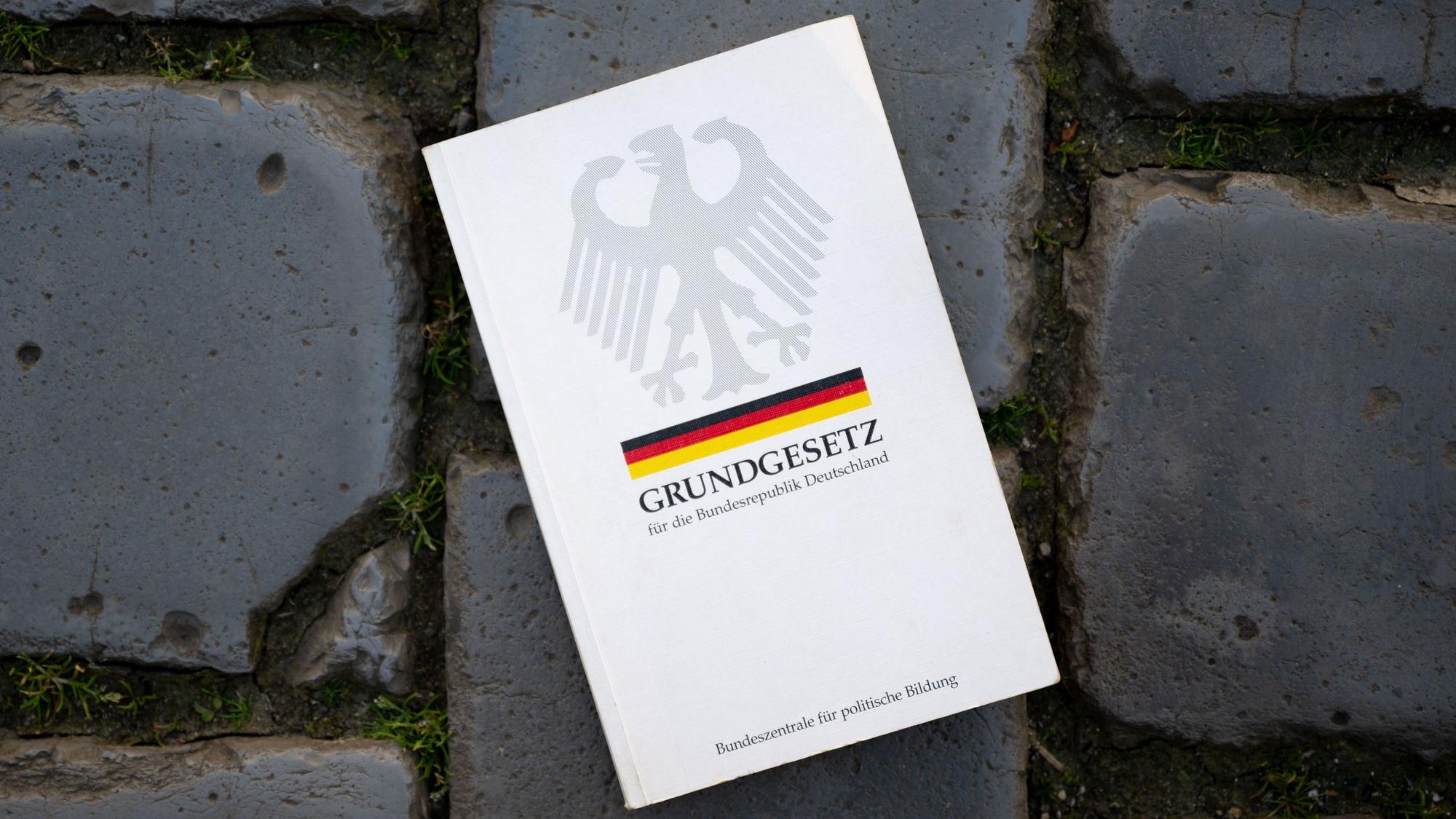 Ein Grundgesetz liegt auf dem Pflaster des Hofes der Nikolaikirche in Leipzig.