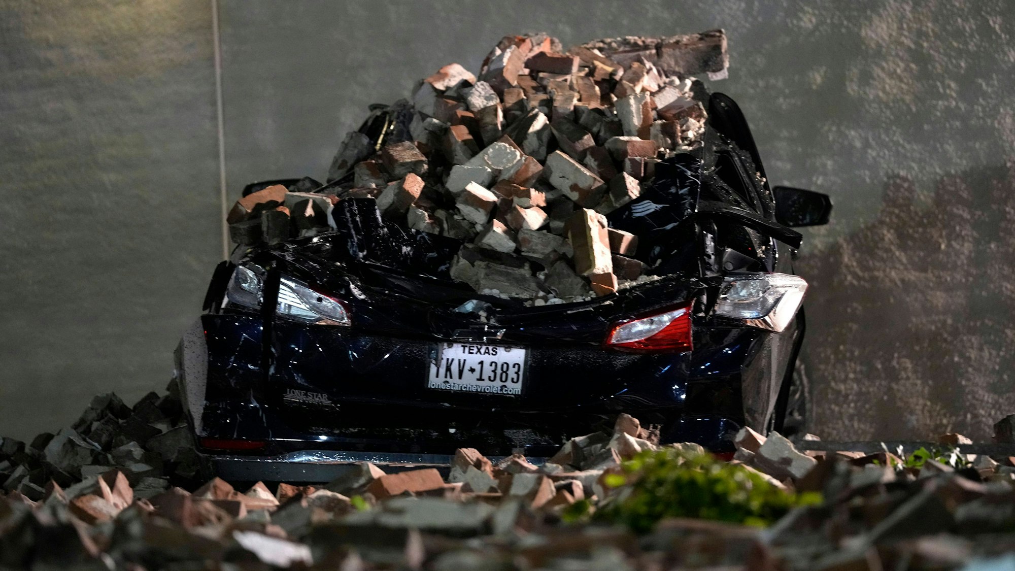 USA, Houston: Ein Auto, das von herabfallenden Ziegeln einer umgestürzten Hauswand zerquetscht wurde, steht auf einem Parkplatz in der Innenstadt, nachdem ein schweres Gewitter vorbeigezogen ist.