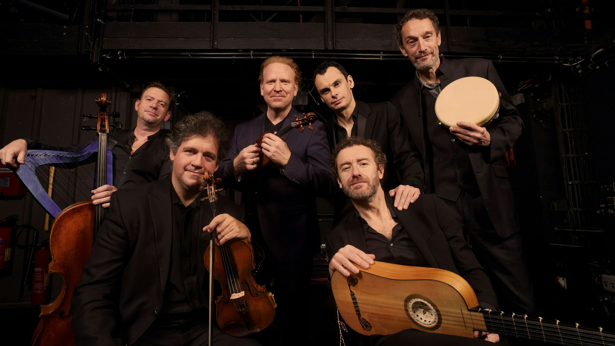 Sechs Musiker mit ihren Instrumenten.