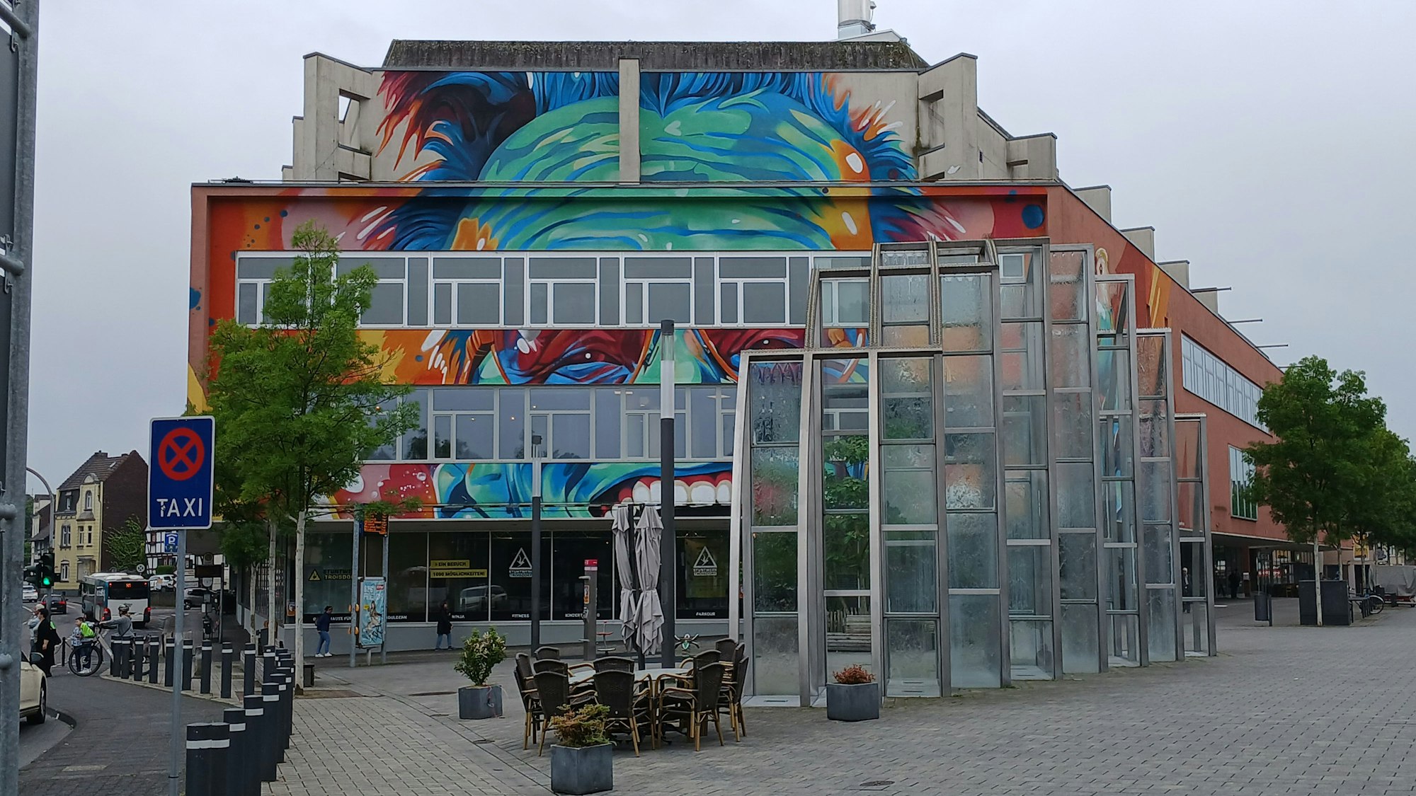 Ein großes buntes Graffiti an einem ehemaligen Warenhaus.