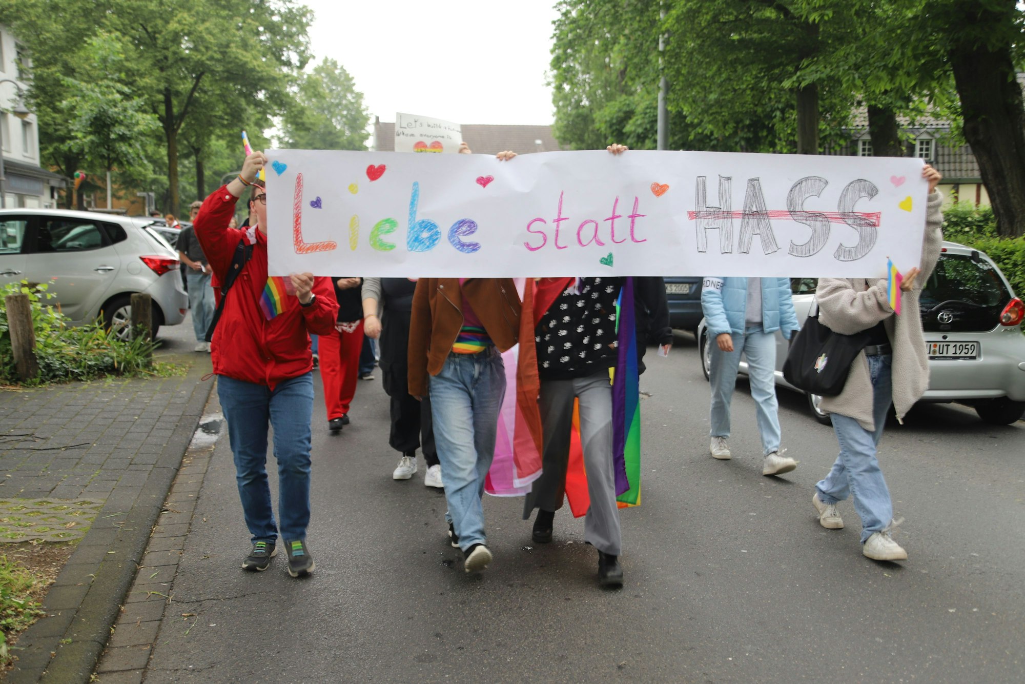 Schüler tragen ein Transparent mit der Aufschrift „Liebe statt Hass“ durch Hennefer Straßen.
