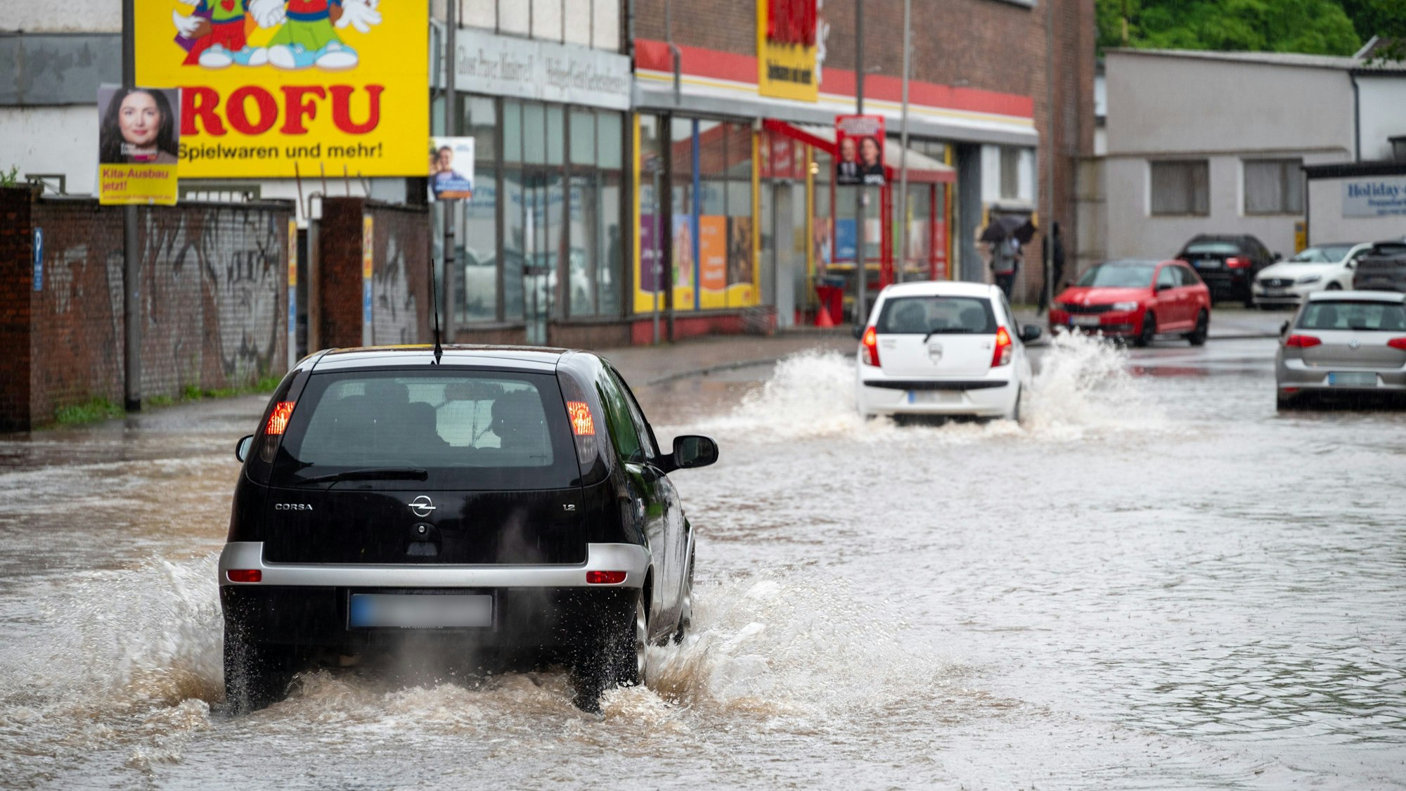 Autofahrer fahren trotz der Überschwemmungen in Saarbrücken durch die steigenden Fluten.