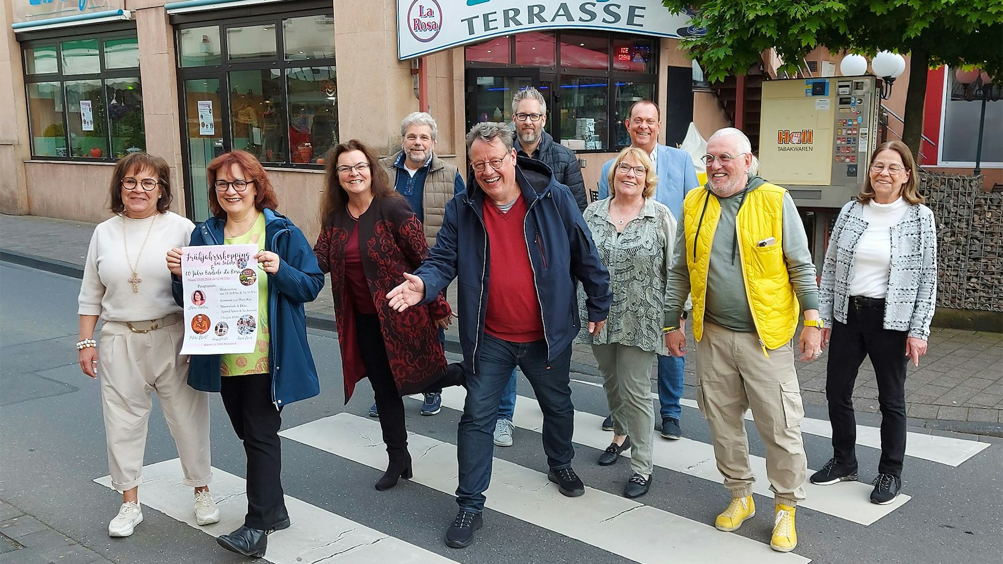 Zahlreiche Männer und Frauen stehen auf einem Zebrastreifen in Mechernich. Sie machen Werbung für die Veranstaltung Rock am Rathaus, die am 25. Mai stattfindet.