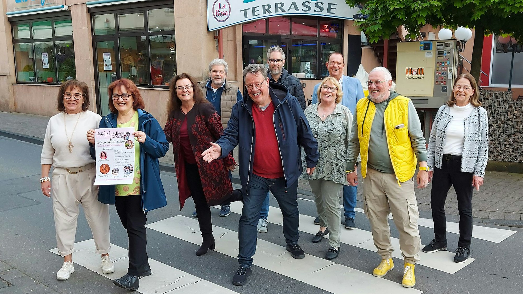 Zahlreiche Männer und Frauen stehen auf einem Zebrastreifen in Mechernich. Sie machen Werbung für die Veranstaltung Rock am Rathaus, die am 25. Mai stattfindet.