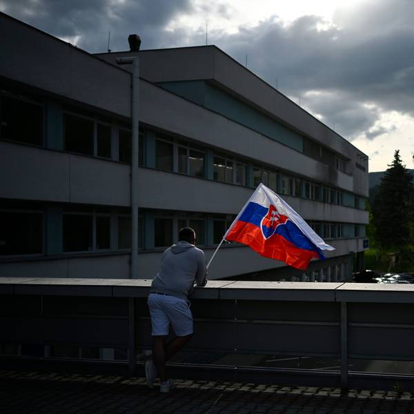 Ein Mann steht mit der slowakischen Flagge am F. D. Roosevelt Universitätskrankenhaus in Banska Bystrica, wo Robert Fico auf der Intensivstation liegt.