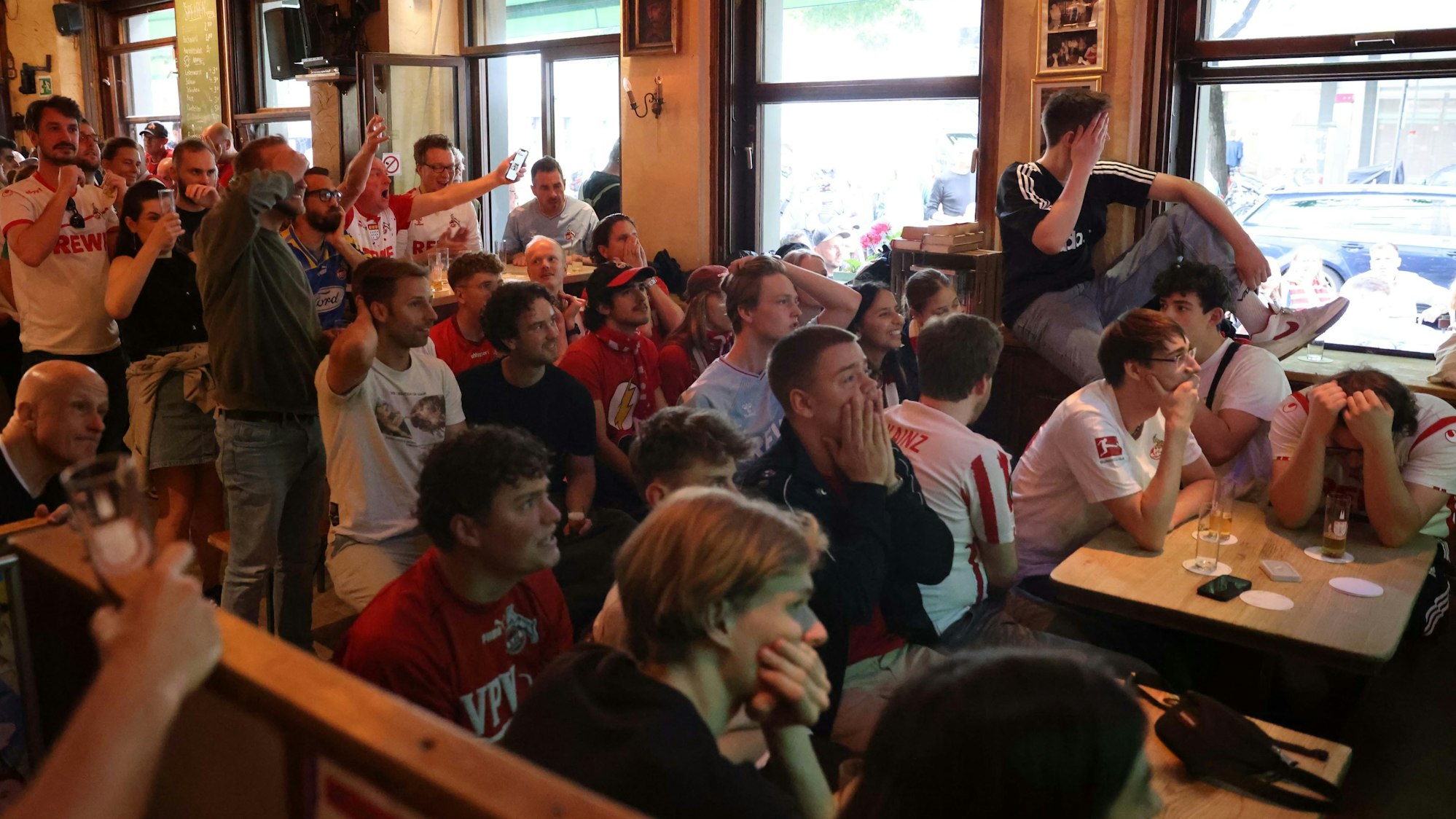 Schock-Starre bei den FC-Fans in der Ubier-Schänke. Nach dem dritten Gegentor war alle Hoffnung dahin. FC-Fans sitzen dichtgedrängt in der Kneipe, halten sich die Hände vors Gesicht, raufen sich die Haare oder sind wütend.