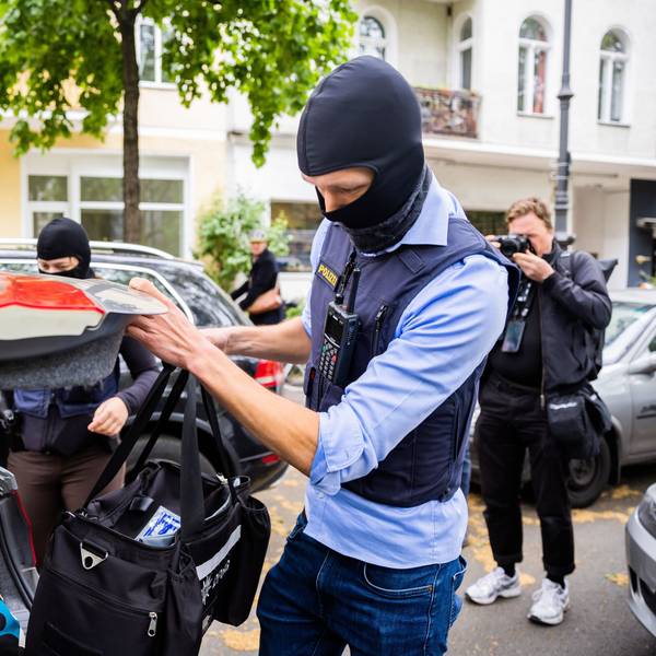 Ein Polizist stellt bei einer Hausdurchsuchung in Berlin-Kreuzberg eine Tasche in ein Fahrzeug. (Archivbild)