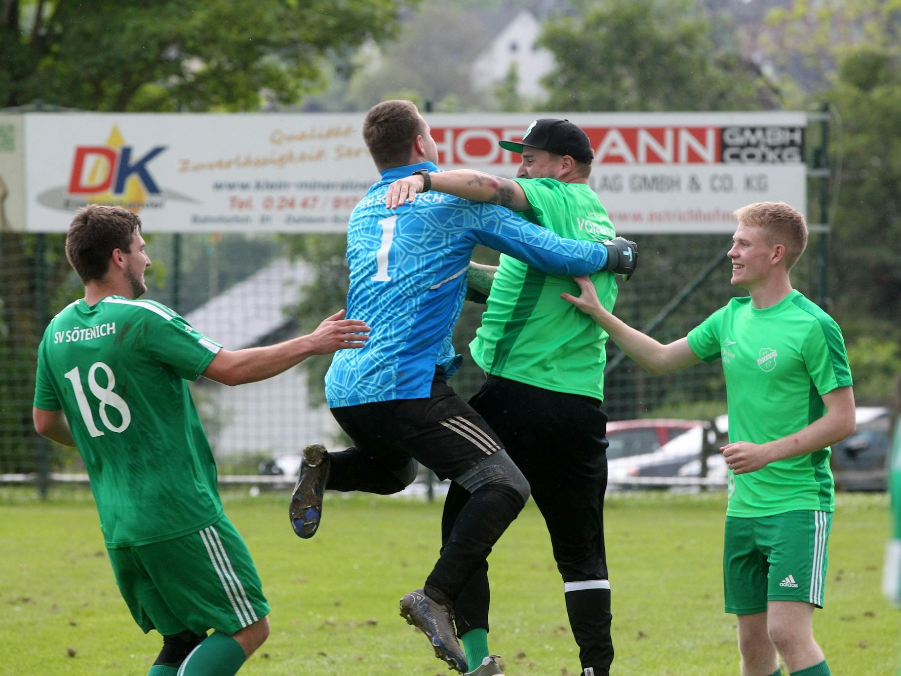 Der Torwart springt seinem Trainer jubelnd in die Arme.