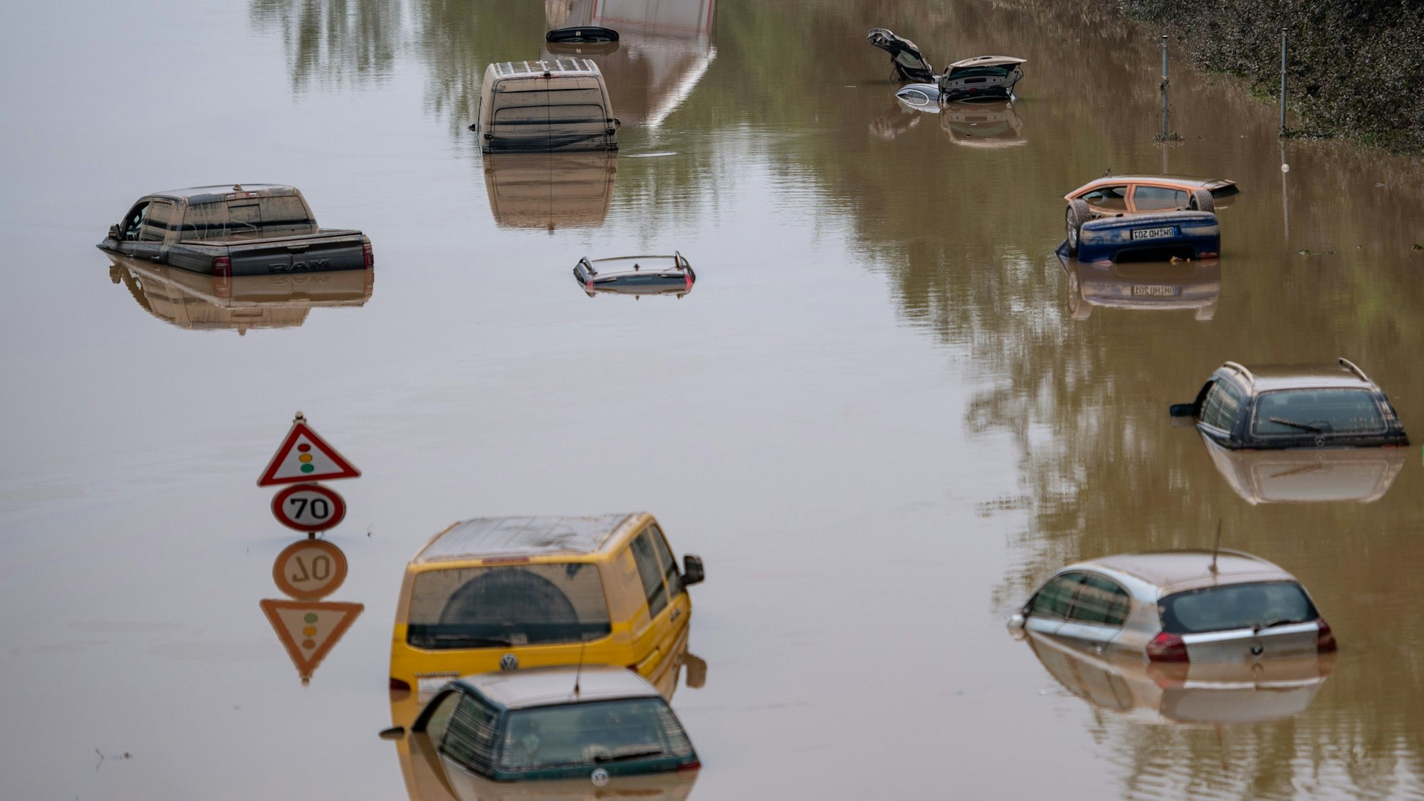 Autos stehen auf der überfluteten Bundesstraße 265 in Erftstadt im Wasser.