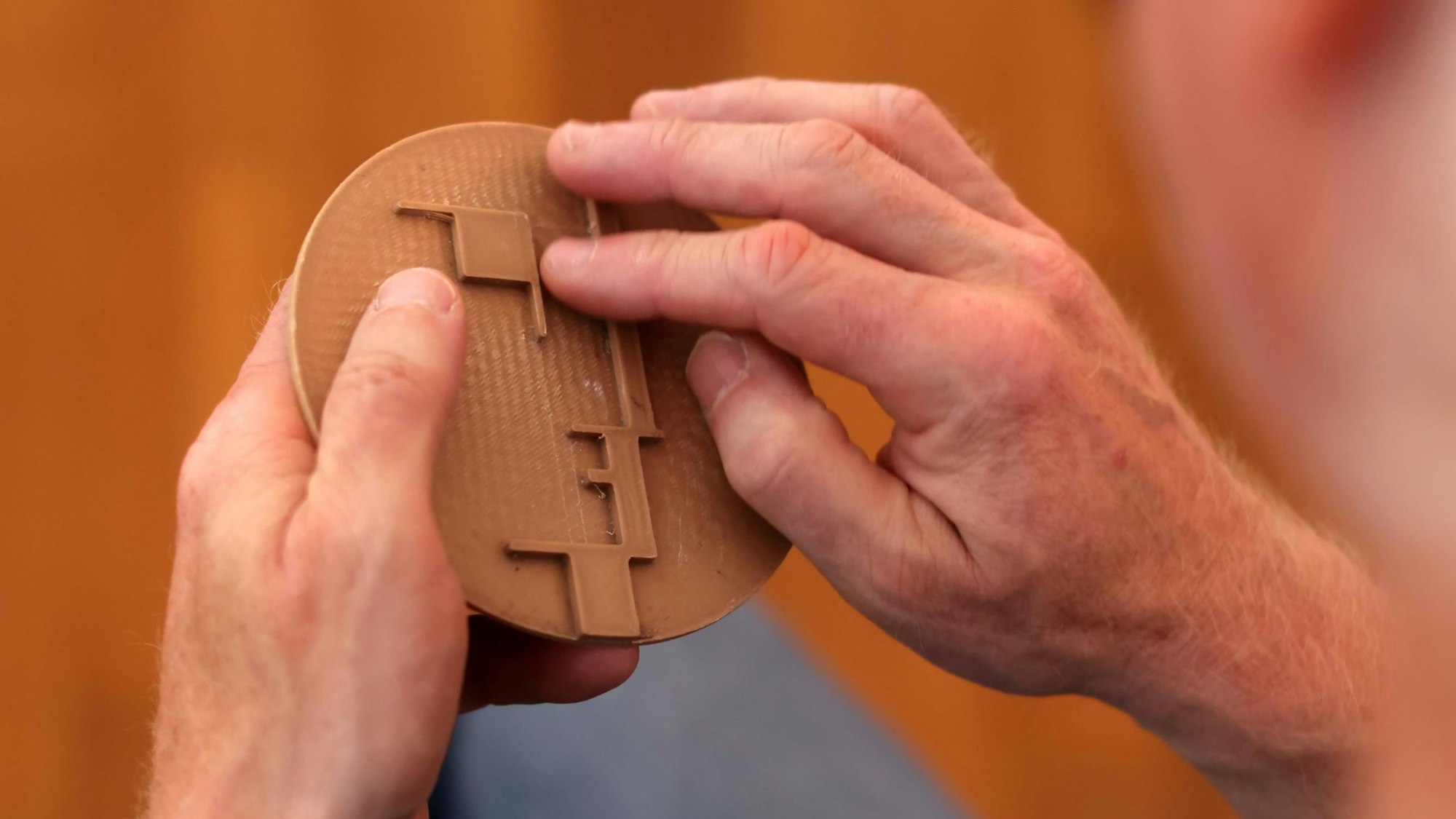 Das Bauhaus-Logo stand als 3D-Druck bereit. Ein Besucher ertastet das Logo-Relief mit seinen Fingern.