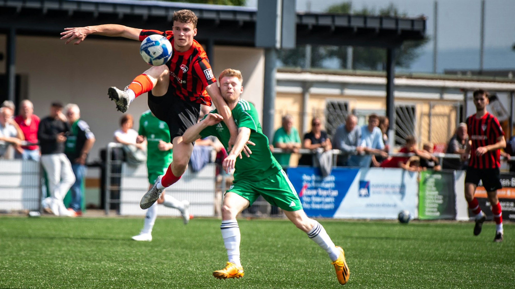 Ein Fußballer nimmt den Ball sehr artistisch an.
