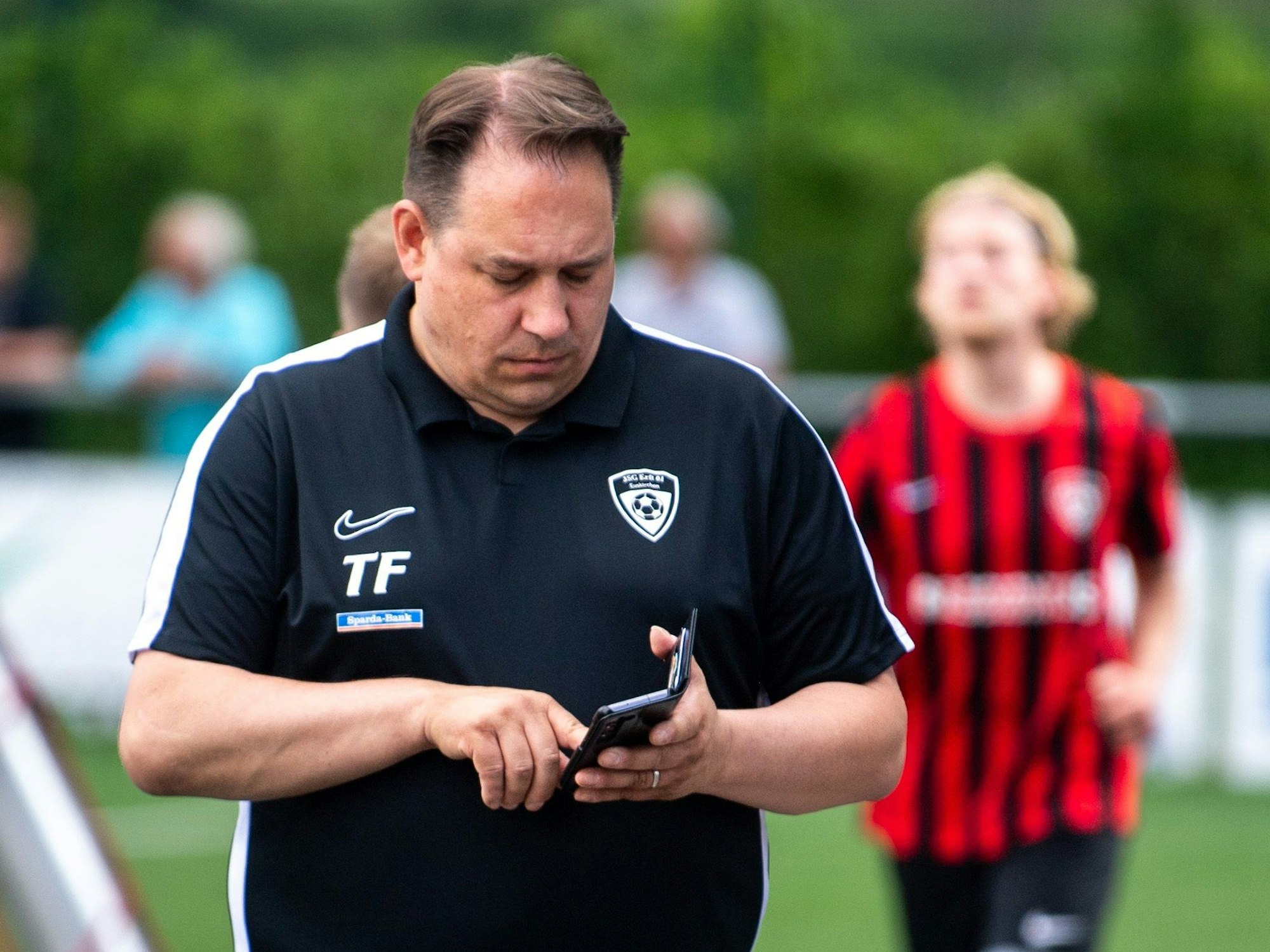 Ein Betreuer schaut auf ein Handy.