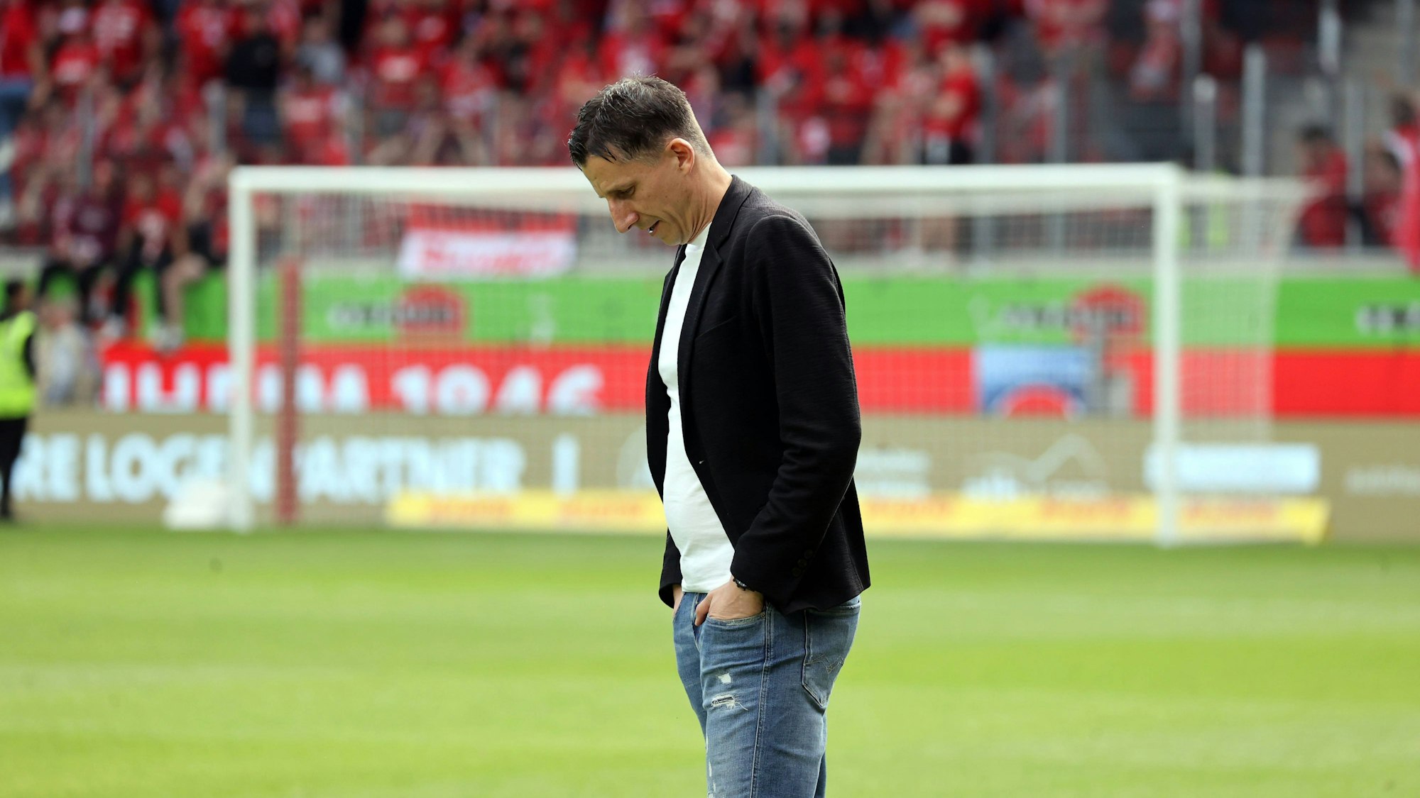 Christian Keller steht mit gesenkten Kopf auf dem Spielfeld.