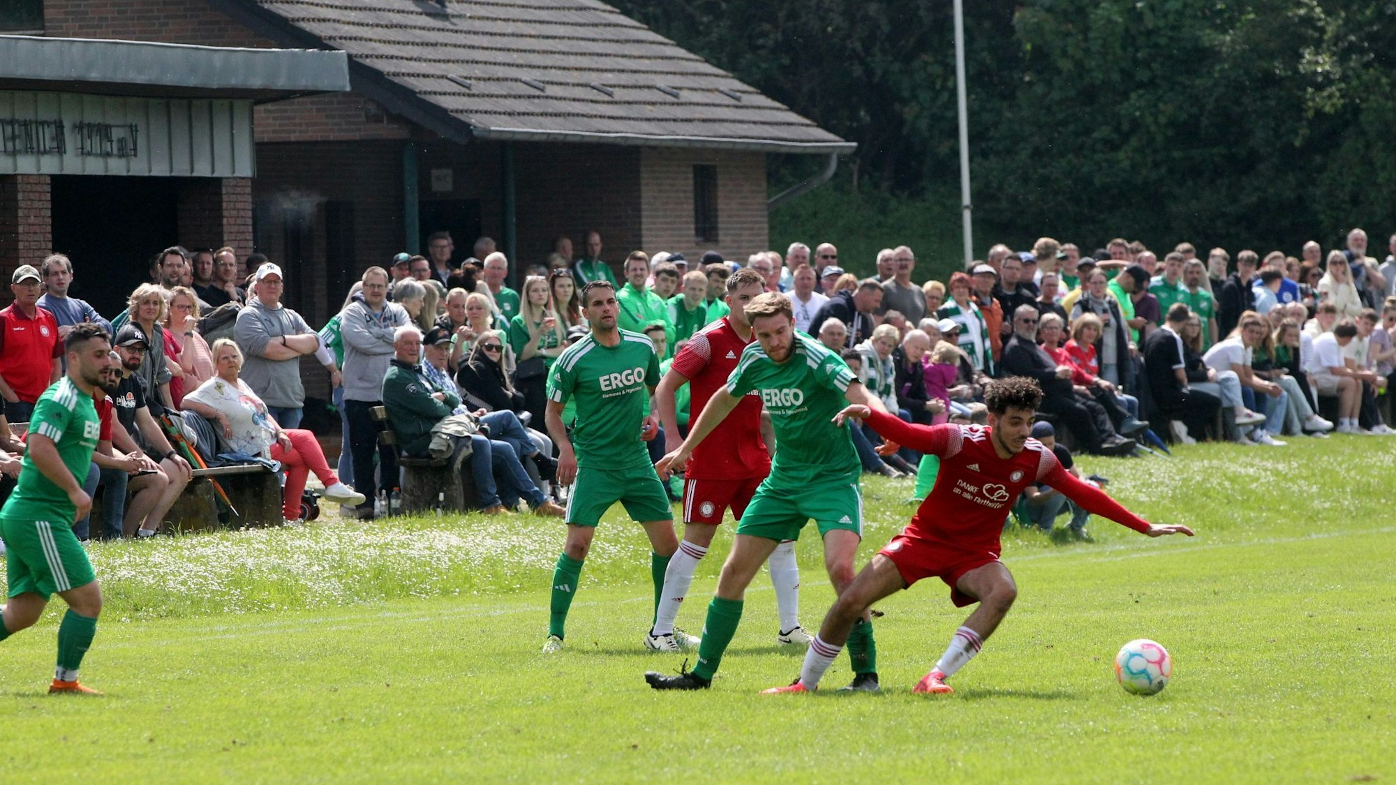 Szene eines Fußballspiels, im Hintergrund viele Zuschauer.