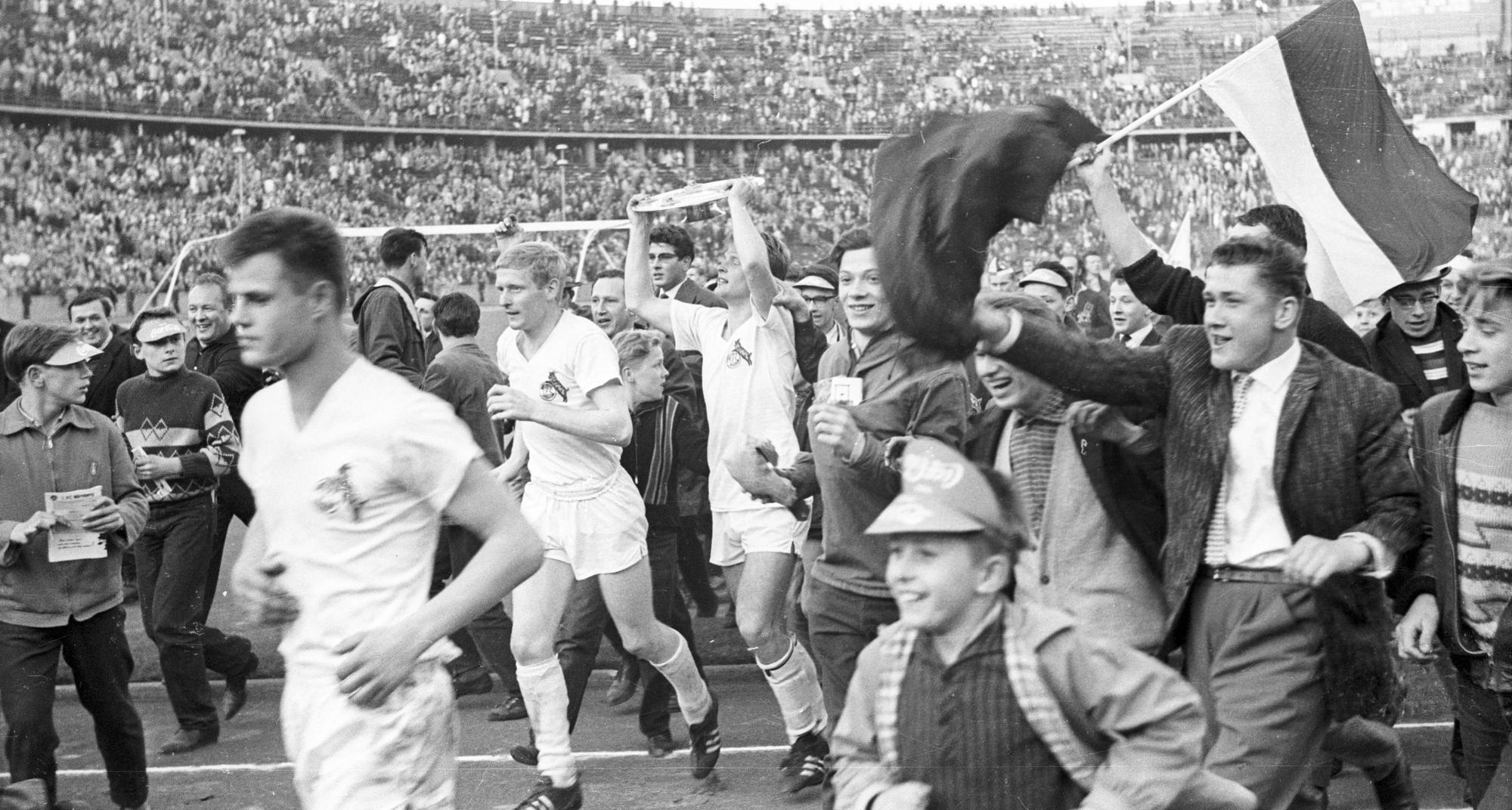 Karl Heinz Thielen präsentiert stolz die Meisterschale, daneben feiern Karl Heinz Schnellinger (li.) und die Fans des 1. FC Köln mit (Archivbild)