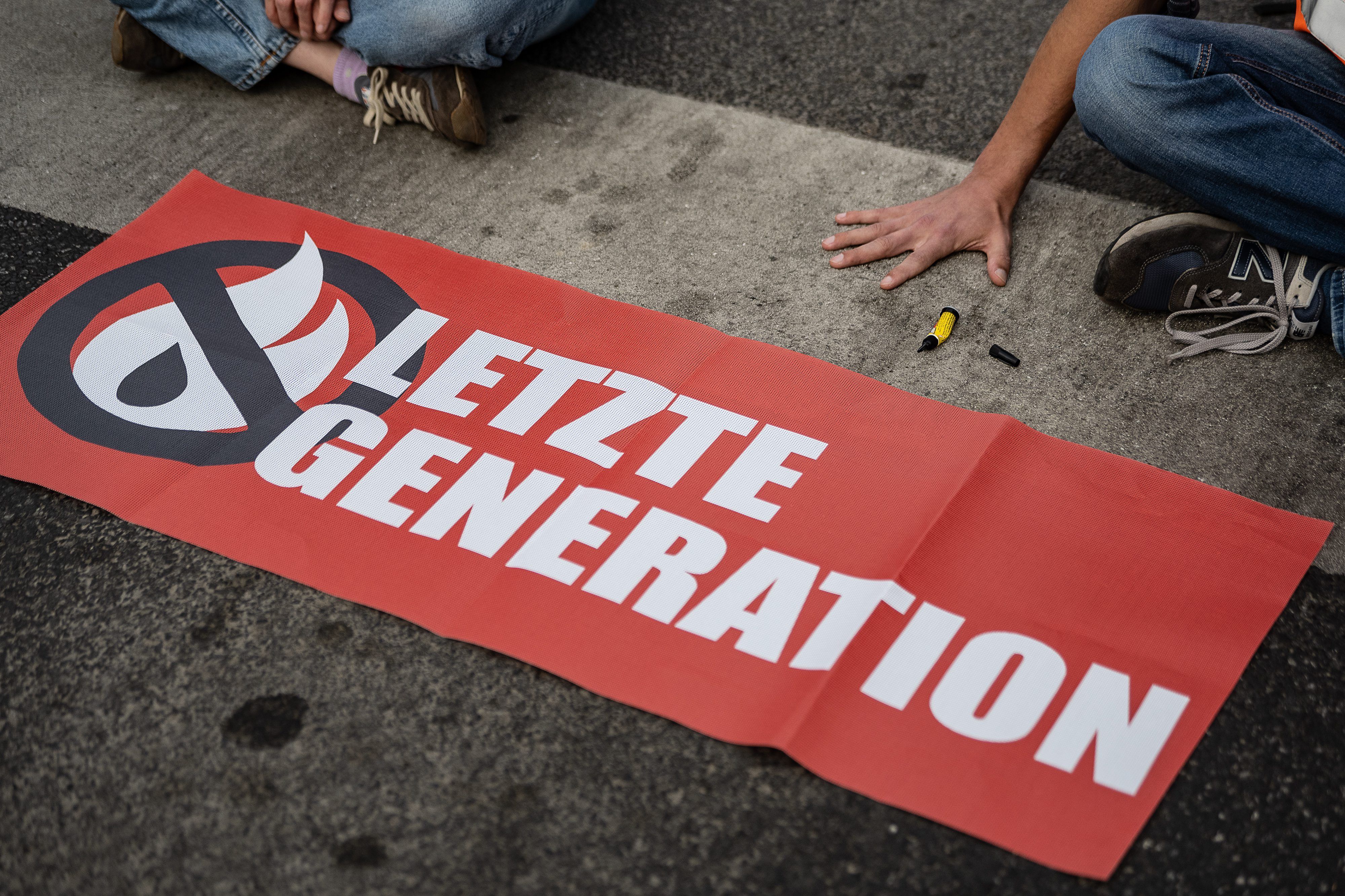 ARCHIV - 16.05.2022, Niedersachsen, Göttingen: Ein Aktivist der Gruppe «Letzte Generation», der seine Hand selbst auf der Straße festgeklebt hat, blockiert eine Kreuzung am Geismar Tor.