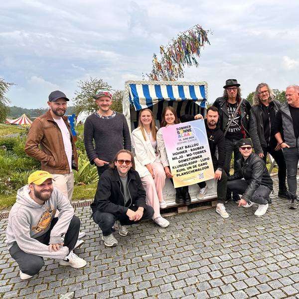 Die Veranstalter von Sommer Sonne Alaaf sowie die Bands Lupo und Domstürmer posieren vor einem Maibaum im Seepark.