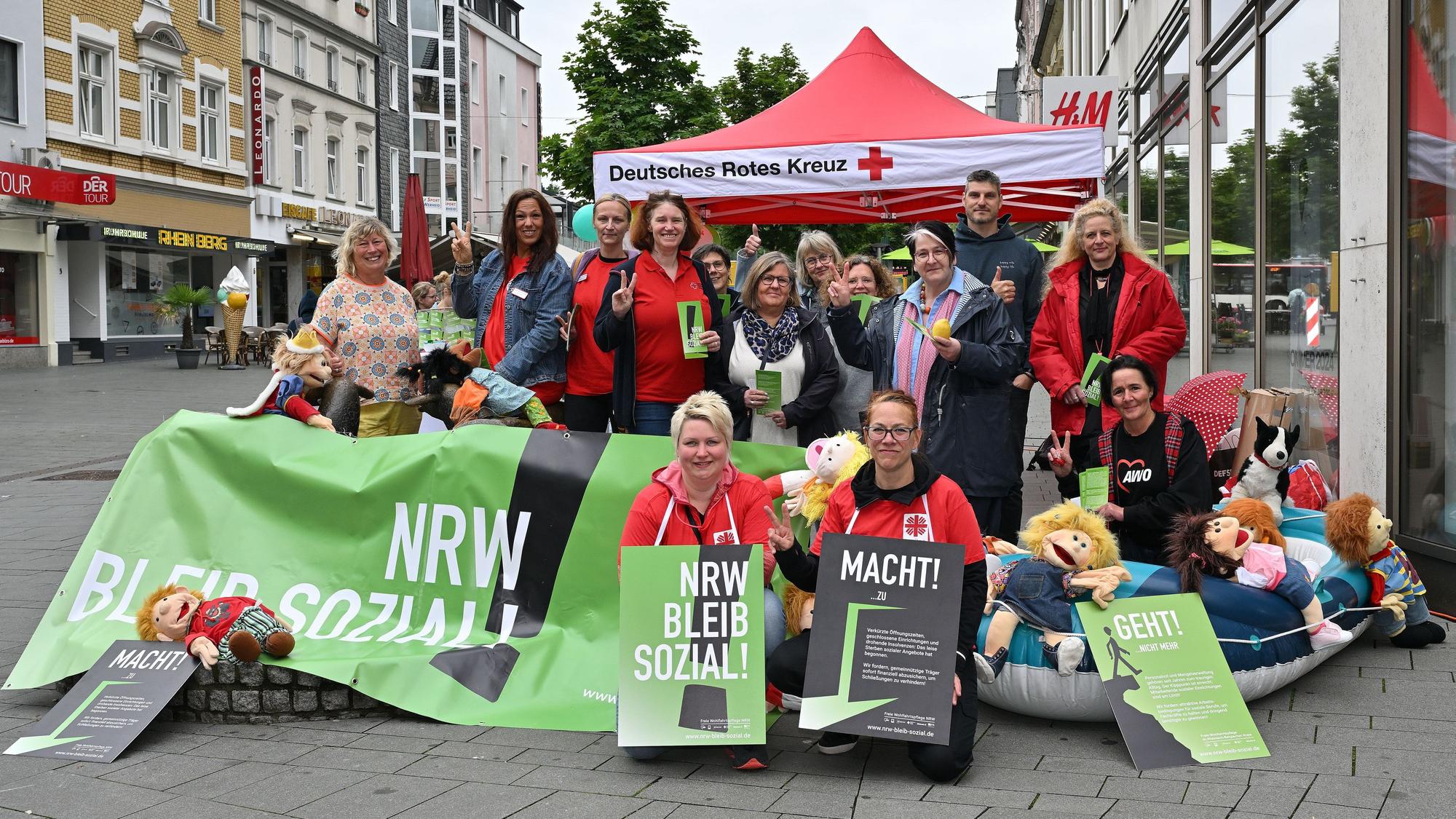Mit Plakaten und einem großen Banner in der Hand haben sich Erzieherinnen und Erzieher für das Foto aufgestellt.