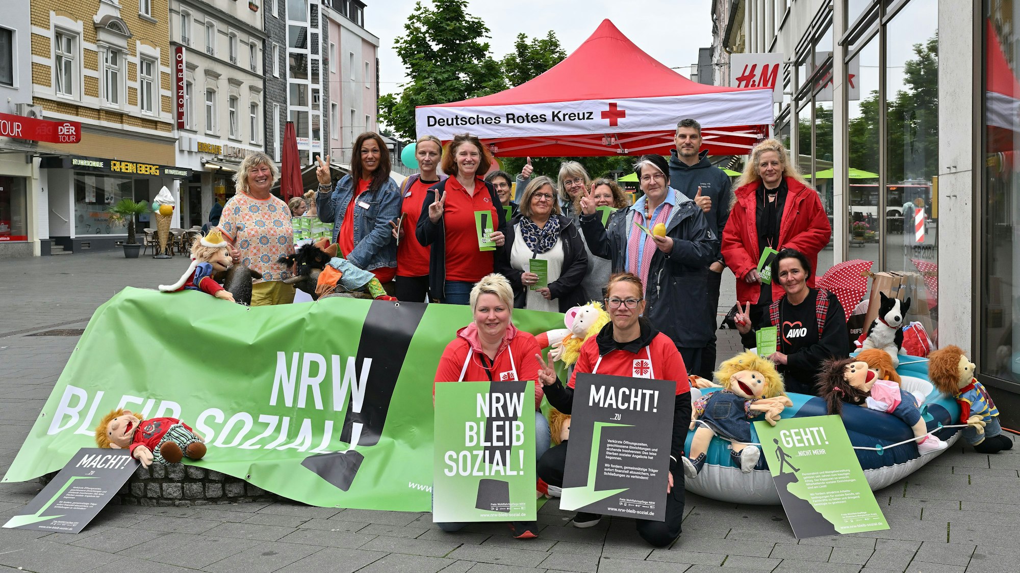 Mit Plakaten und einem großen Banner in der Hand haben sich Erzieherinnen und Erzieher für das Foto aufgestellt.