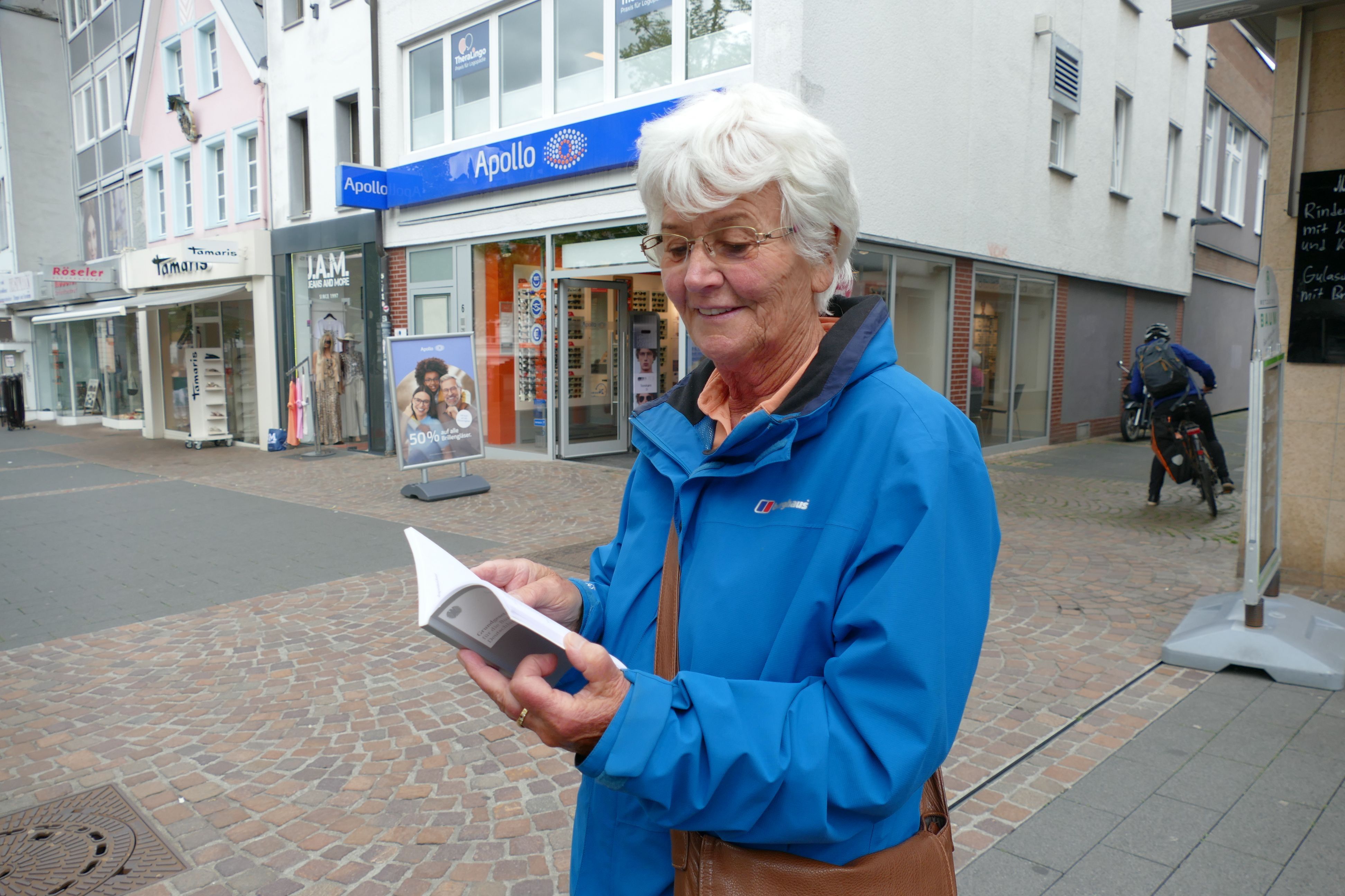 Eine Frau hält ein Grundgesetz in der Hand.