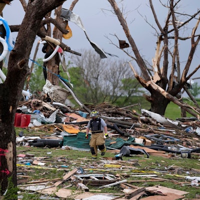 Ein Feuerwehrmann geht in Greenfield, Iowa, zwischen von einem Tornado zerstörten Häusern umher.