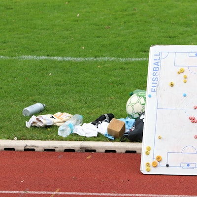 Das Bild zeigt eine Taktiktafel am Spielfeldrand. Sie lehnt an einer Auswechselbank.