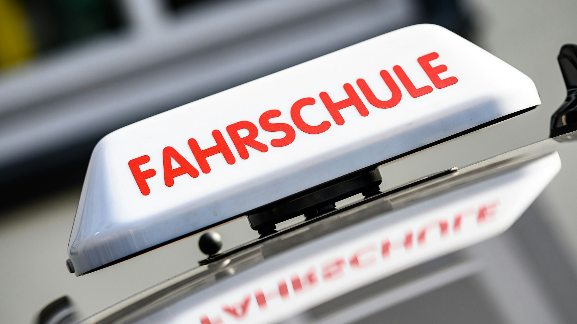 Ein Dachzeichen mit der Aufschrift "Fahrschule" ist an einem Fahrschulauto angebracht.