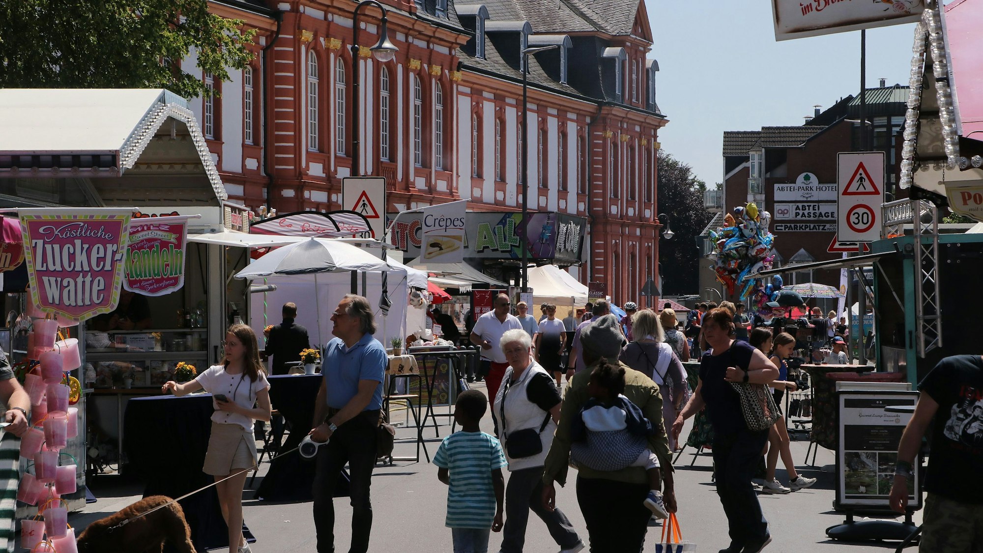 Menschen tummeln sich an Ständen auf der Ehrenfriedstraße vor der Abtei Brauweiler.