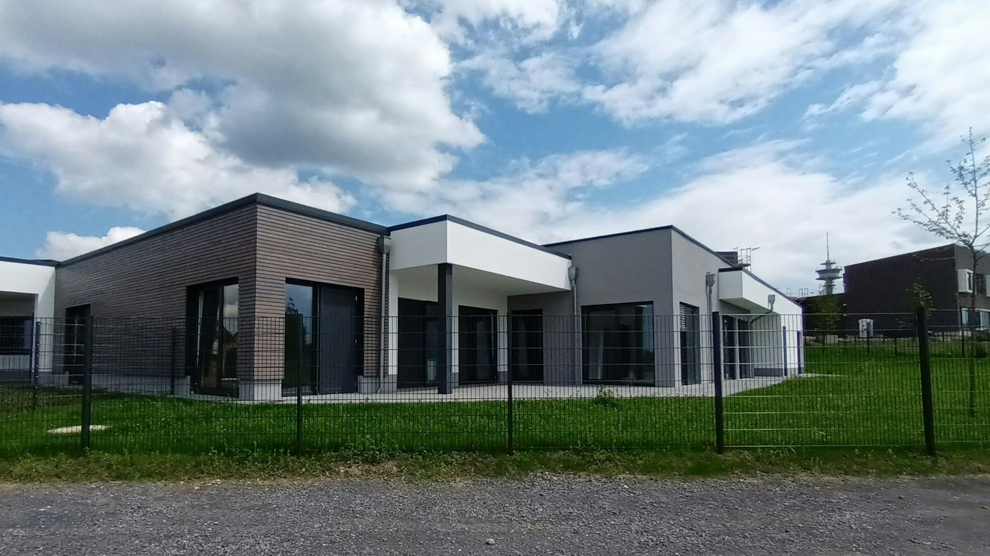 Zwei Gebäude, dahinter ein Fernmeldeturm