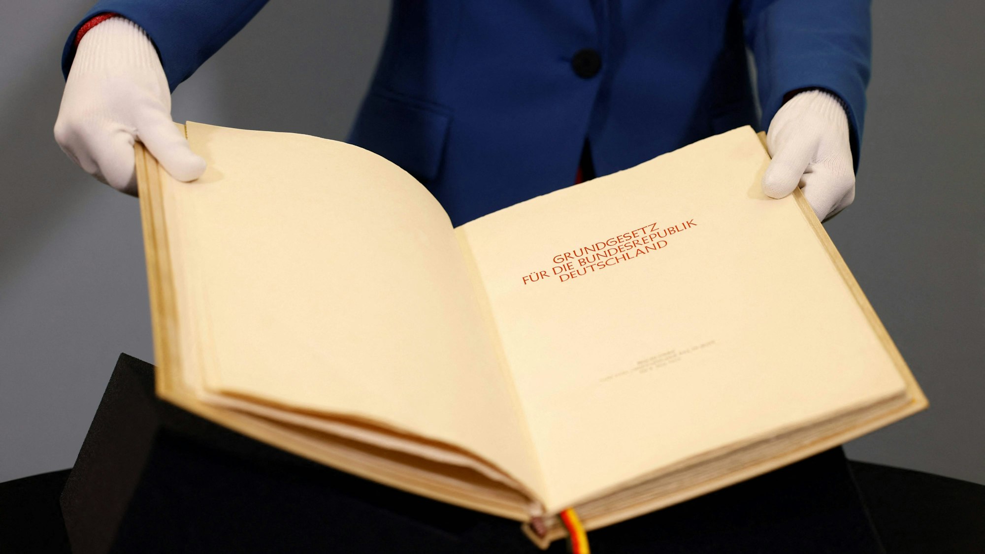 Eine Person hält das Grundgesetz in den Händen.