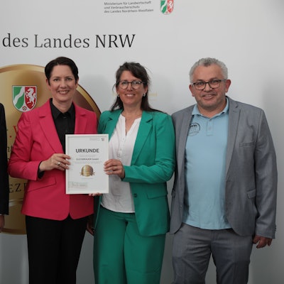 Auf dem Bild ist die Übergabe des Ehrenpreises zu sehen.