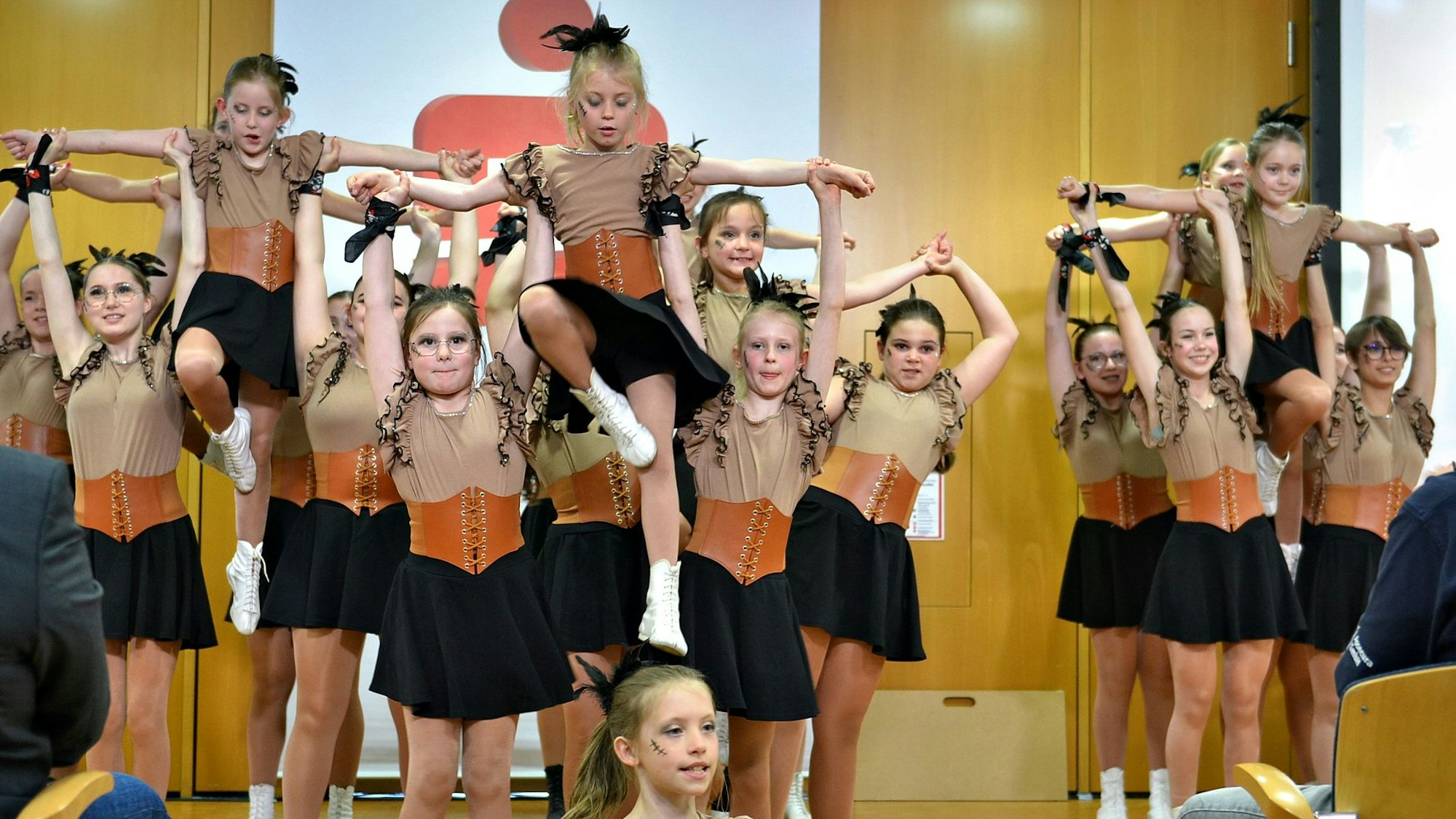 In ihren Kostümen stehen die Tänzerinnen auf der Bühne, einige werden von den anderen hochgehoben.