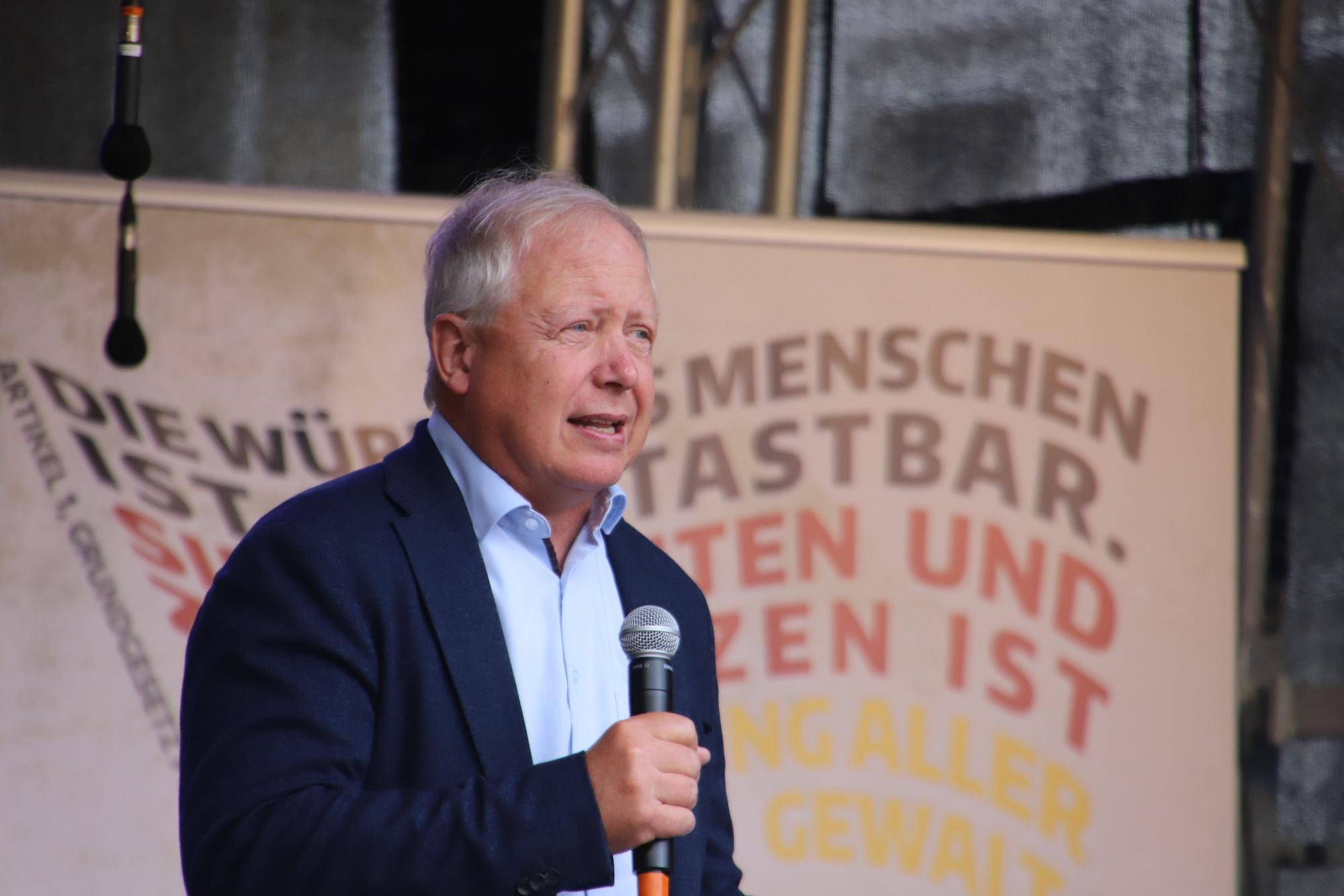 WDR-Intendant Tom Buhrow hat ein Mikrofon in der Hand und hält eine Rede.