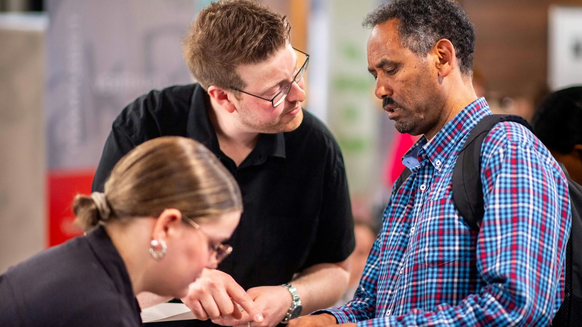 Das Bild zeigt Christian Mahlberg im Gespräch mit einem Mann, der einen Flyer in der Hand hält.