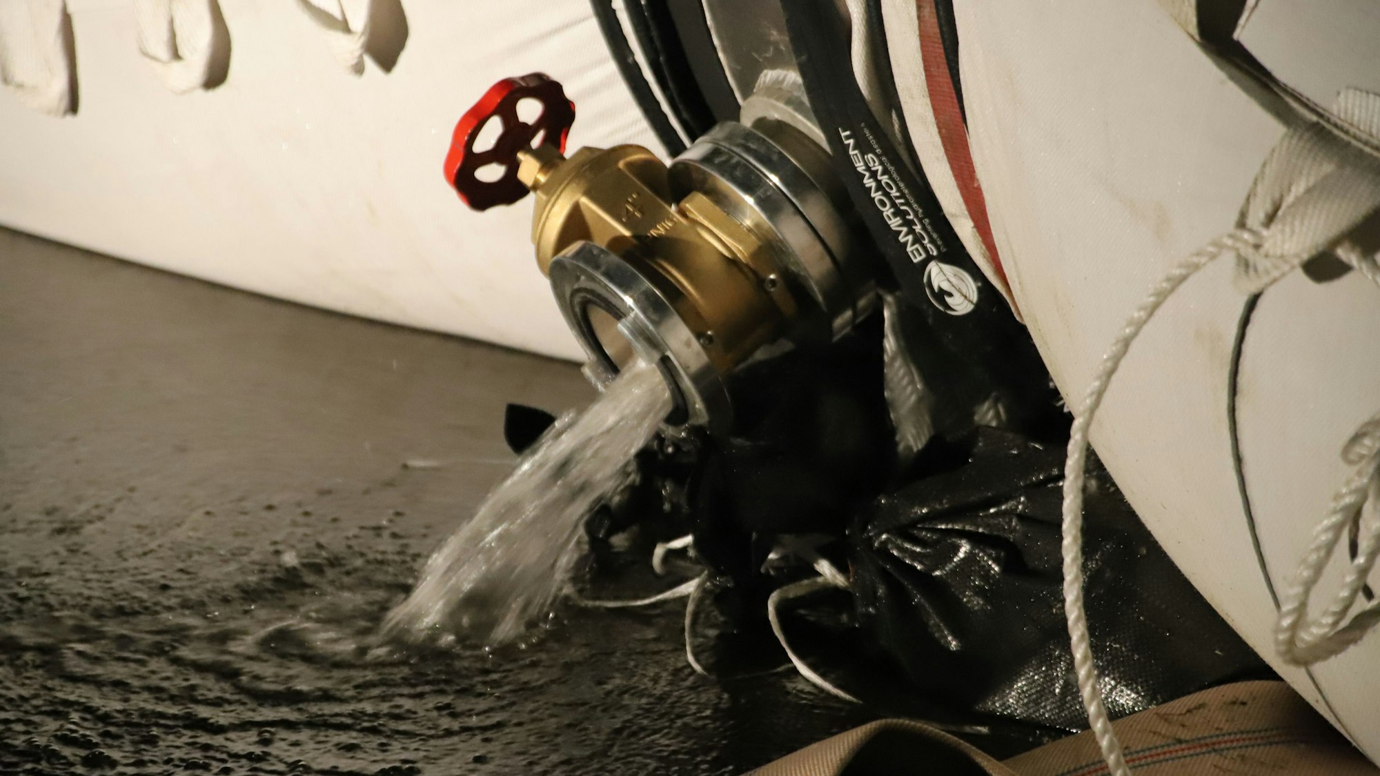 Aus einem Ventil läuft das Wasser aus einem Plastikschlauch.