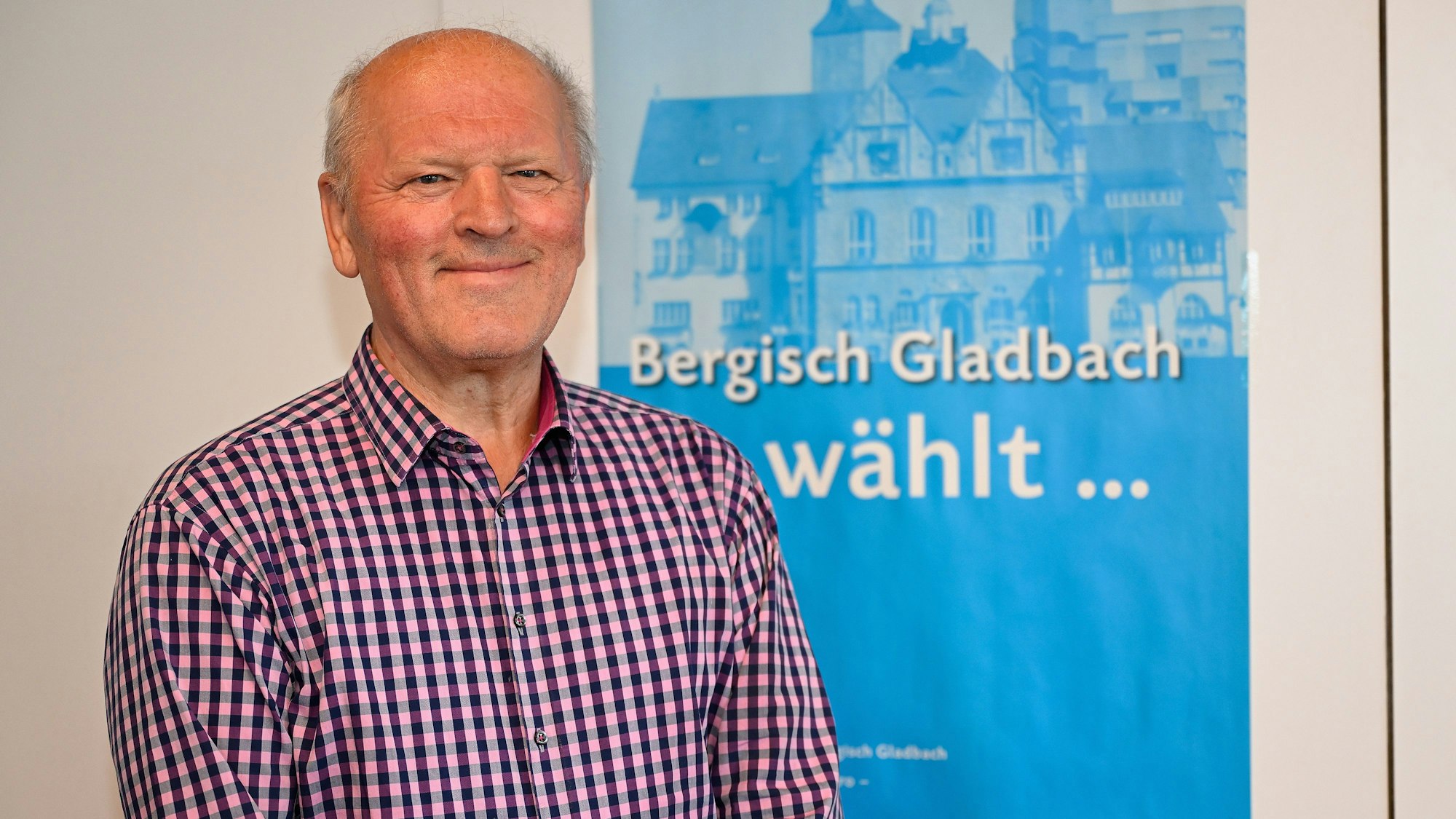 Porträtfoto von Herbert Kurek vor einem Wahlplakat zur Europawahl.