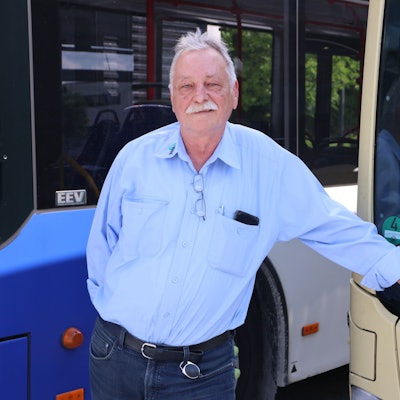 Sergej Jakowlew steht vor einem Linienbus.