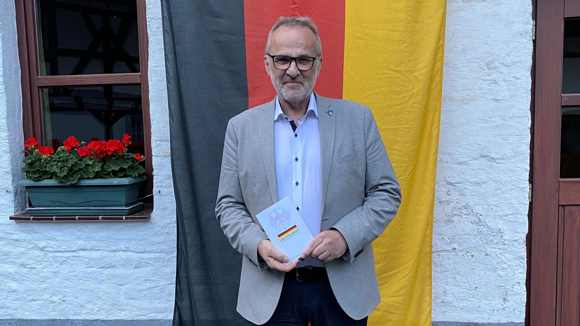 Feier zum 75-jährigen Geburtstag des Grundgesetzes in Wachtberg. Bürgermeister Jörg Schmidt mit dem Grundgesetz im Köllenhof.