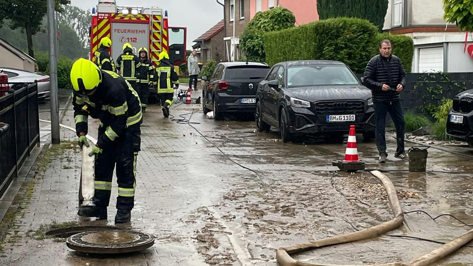 Das Foto zeigt einen Feuerwehrmann an einem Kanalschacht.