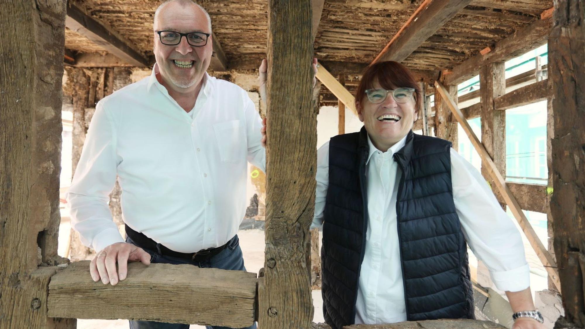Ein Mann und eine Frau stehen im Erdgeschoss eines Fachwerkhauses.