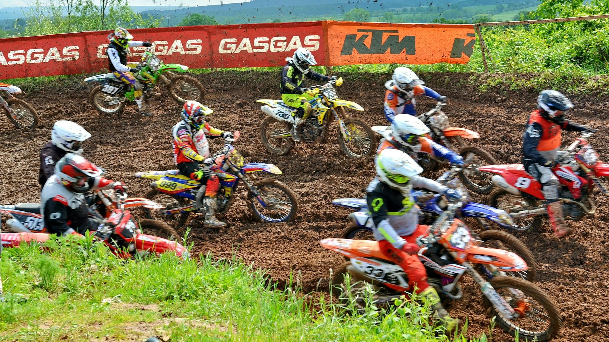 Blick von oben auf viele Motorradfahrer, die gemeinsam starten.