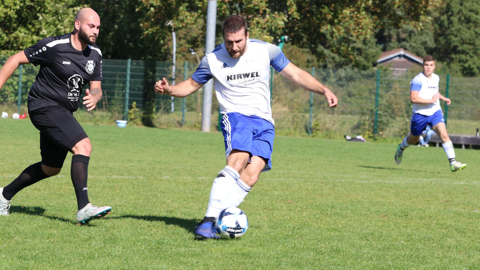 Das Bild zeigt Alexander Huth, wie er einen Ball schießt. Sein Gegenspieler kommt zu spät.