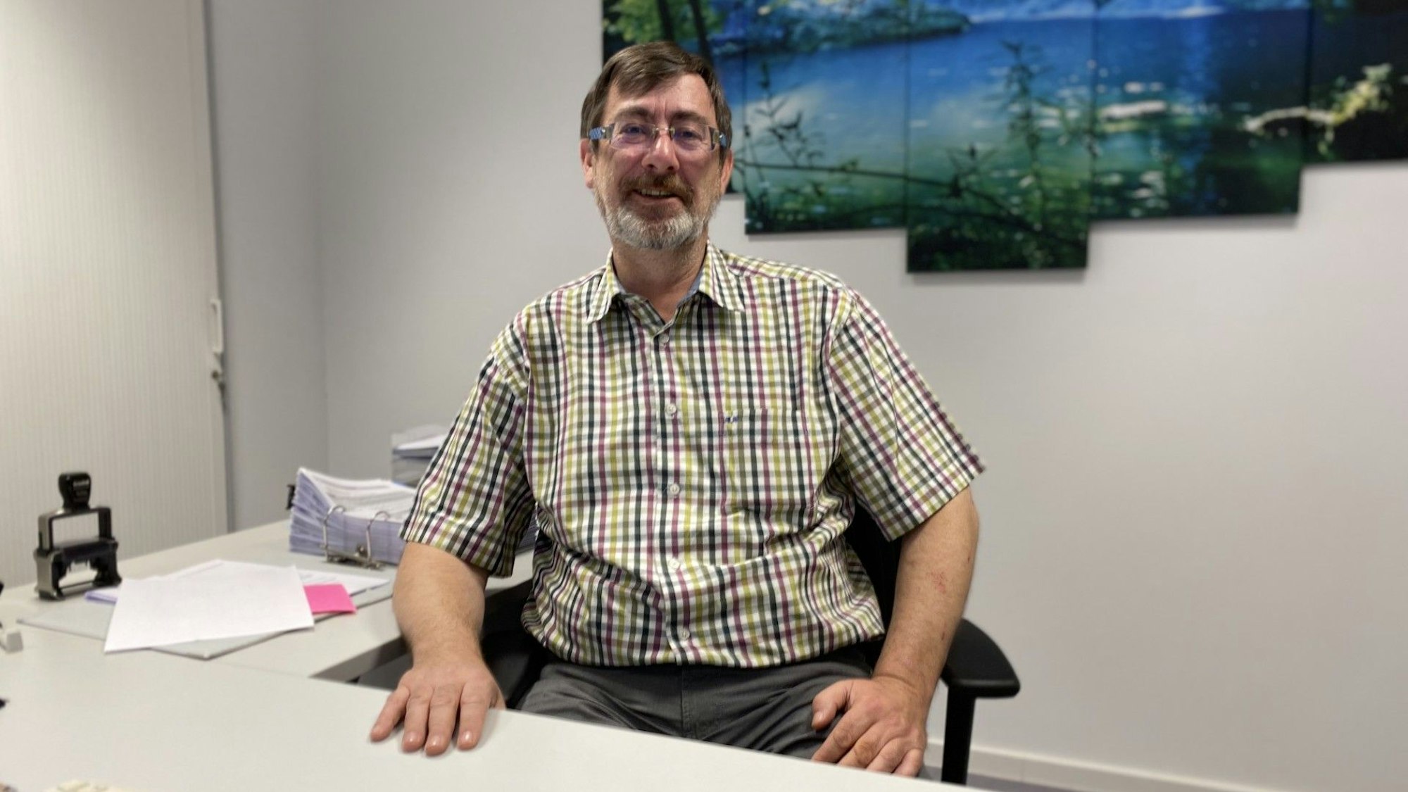 Horst Reiter sitzt hinter dem Schreibtisch der Gemeindeverwaltung Büllingen.