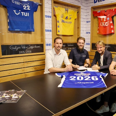 Bei der Vertragsunterzeichnung: Christoph Schindler, Florian Lister, Markus Krampe und Dennis Römer sitzen nebeneinander. Vor ihnen liegt ein VfL-Trikot mit der Nummer 2026.