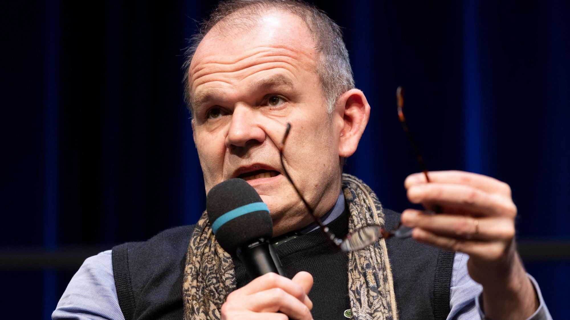 Generalmusikdirektor Francois-Xavier Roth spricht in ein Mikrofon.